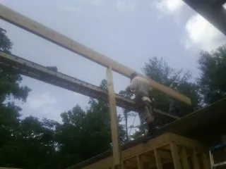 Carpenter setting a ridge beam over a new addition frame — Ice Dam Removal by Roofing Brothers in Mishawaka