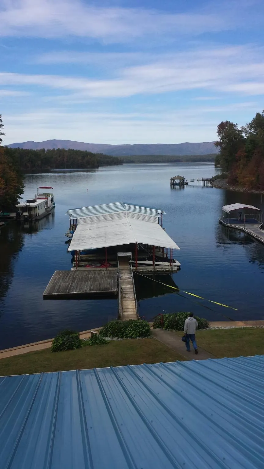 View across a lake from a newly installed blue metal roof in Mishawaka