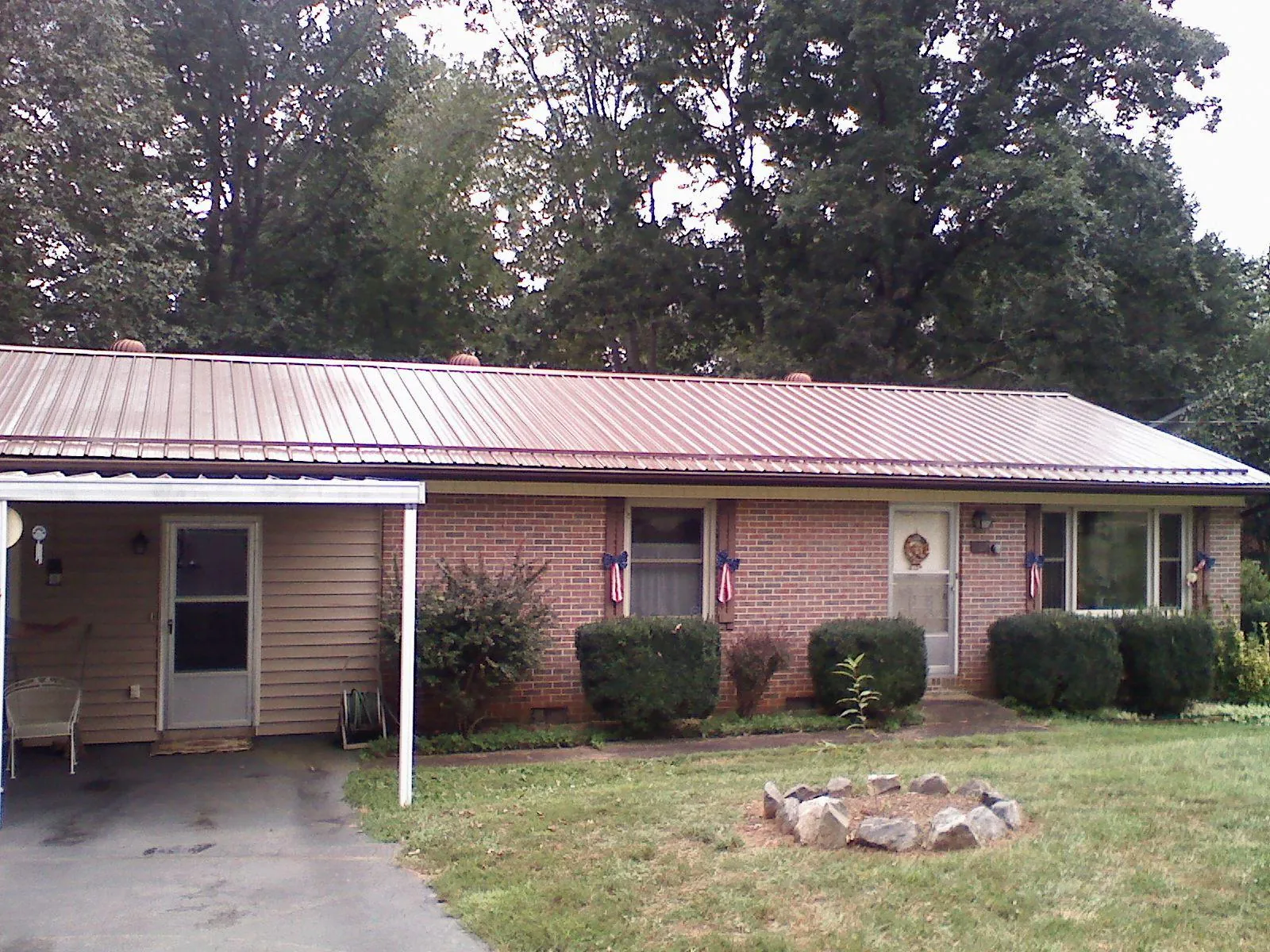 Bronze metal roof and carport on a brick ranch home — Roof Repair work by our crew in Mishawaka